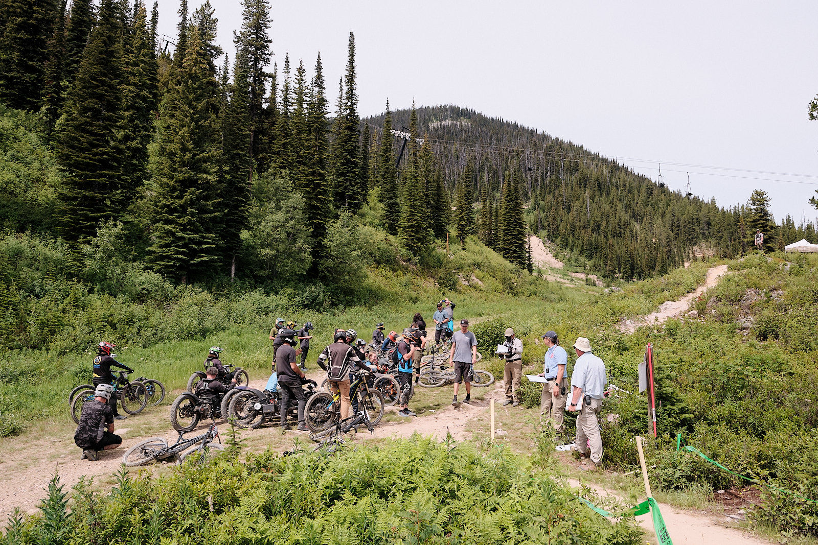 Trail crew gathered in a mountain meadow with adaptive mountain bikes